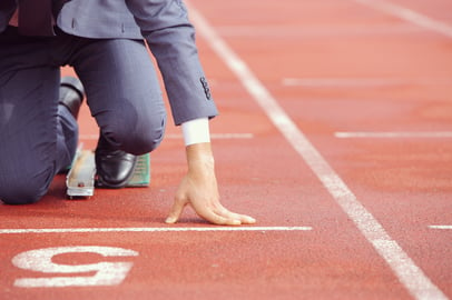 Businessman on racing blocks at starting line